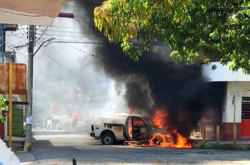 Una de las camionetas de la fiscalía arde en llamas después del ataque de los delincuentes.