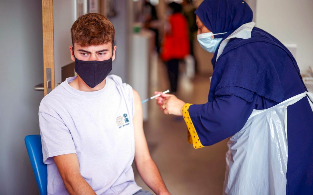 Un joven recibe una dosis contra el coronavirus en el hospital Central de Middlesex, en Londres.