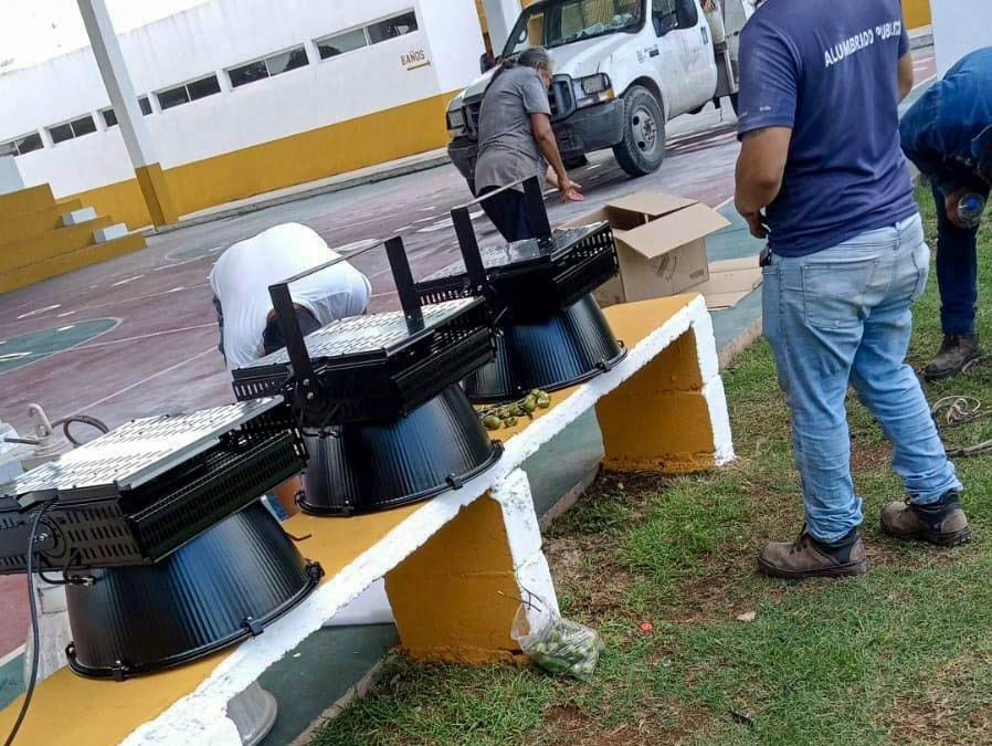 Trabajadores municipales del departamento de alumbrado público cambian lamparas en la Unidad Deportiva de la colonia Fernando Novelo.