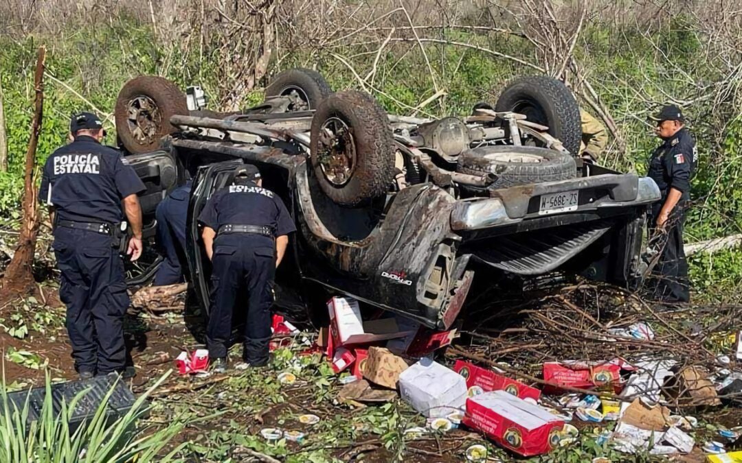 Policías estatales durante las labores para rescatar a los ocupantes de la camioneta volcada.