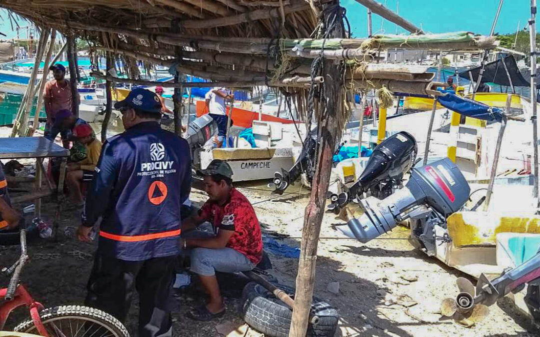 Personal de Protección Civil conversando con pescadores del puerto de Sisal.