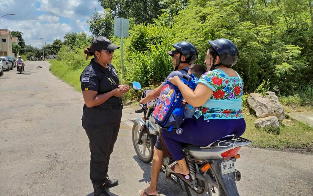 Elemento policiaco platicando con el conductor de una motocicleta sobre los riesgos de llevar mas pasajeros de la capacidad permitida, así como del uso del casco protector.