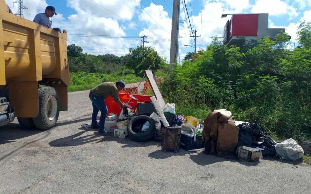 Personal del municipio recogiendo la gran cantidad de residuos que la gente ha sacado a las esquinas de sus casas con la finalidad de eliminar los criaderos de mosquitos en la ciudad.