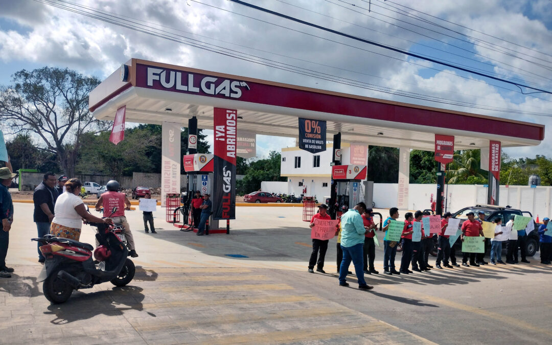 Protesta de trabajadores de la gasolinera clausurada por el municipio por no contar con la documentación completa para funcionar. Una usuaria acudió a llenar el tanque de su motoneta.
