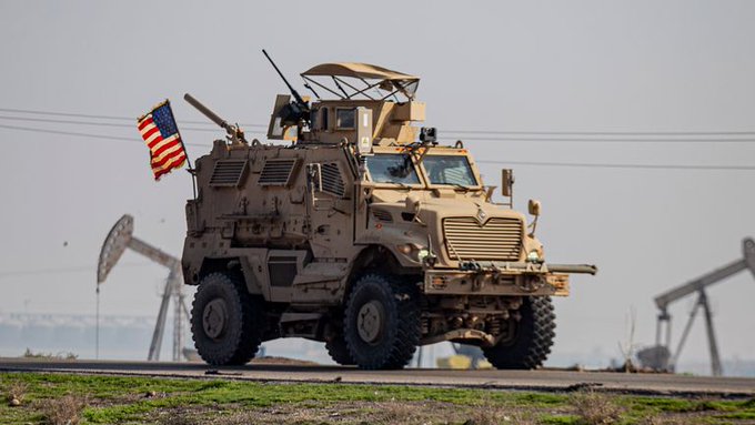 Vehículo blindado estadounidense para el transporte de personal monta guardia en un campo de extracción petrolera.